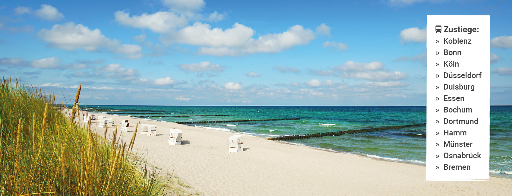 Weißer Sandstrand auf Sylt an der Nordsee mit Strandkörben, bewachsenen Dünen und türkisblauem Meer.