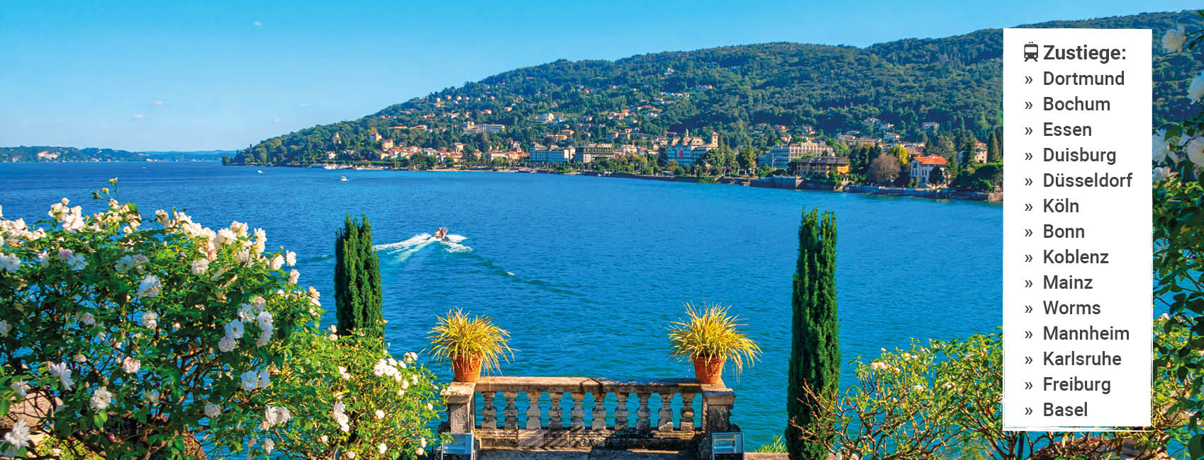 Blick von den Borromäischen Inseln auf den Lago Maggiore mit mediterraner Gartenanlage, blauem See und bewaldeter Uferlandschaft.