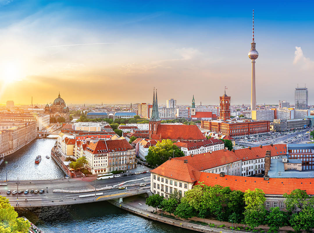 Panoramablick über die Berliner Innenstadt mit Fernsehturm, Rotem Rathaus, Berliner Dom und der Spree im Abendlicht.